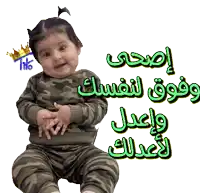a baby with a crown on her head is sitting next to a sign in arabic
