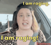 a woman is sitting in a car with the words `` i am raging '' written above her .