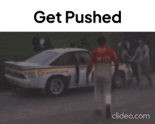 a man is pushing a race car with the words `` get pushed '' above him .