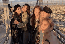 a group of young women are posing for a picture on top of a ferris wheel