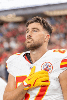 a man wearing a red white and yellow nfl jersey