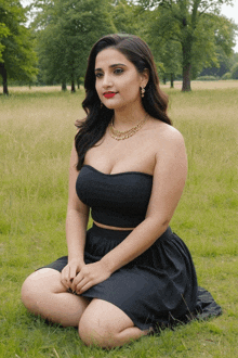 a woman in a black dress is kneeling down in a field