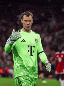 a soccer player wearing a green shirt with the letter t on it