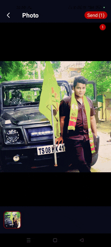 a man standing in front of a car with a yellow flag and a license plate that says ts 08 k41