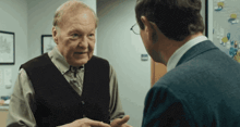 two men are talking to each other and one has glasses on