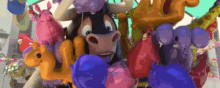 a cartoon cow is surrounded by balloons and a bunch of balloons .