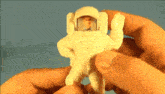 a person is holding a toy astronaut in their hand