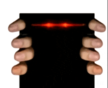 a person 's hands are holding a black object with red lights coming out of it