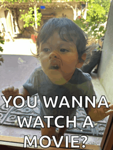 a baby looking out a window with the words " you wanna watch a movie " on the bottom