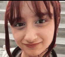 a close up of a girl 's face with red hair