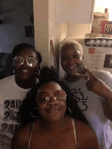 three women are posing for a picture with one wearing a 24 on her shirt