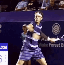 a tennis player is swinging a tennis racquet on a court in front of a sign that says wake forest bank .