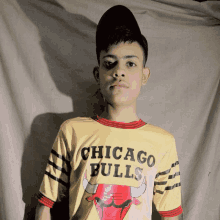 a young boy wearing a yellow shirt that says chicago bulls