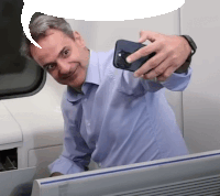 a man in a blue shirt takes a selfie with his phone