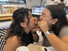 a woman wearing a watch is eating a strawberry