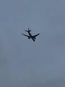 a plane is flying through a cloudy sky with a gray background