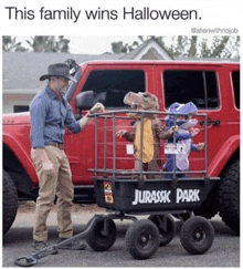 a man pulling a wagon with two children in jurassic park costumes