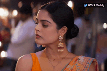 a woman wearing earrings and a necklace with 7wickreddy written in the corner