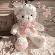 a white teddy bear wearing a lace dress and a pink bow