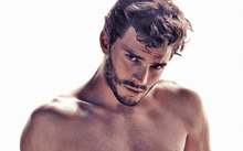a shirtless man with curly hair and a beard