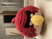 a red angry bird with a yellow beak sits on a bathroom sink