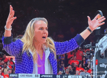 a woman stands on a basketball court with her arms in the air and the scoreboard says las vegas 88 phoenix 86