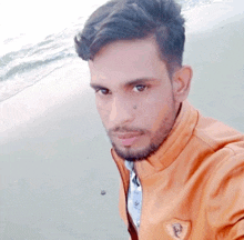 a man with a beard is taking a selfie at the beach .