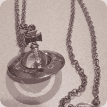 a vivienne westwood necklace with a pink pendant on a silver chain