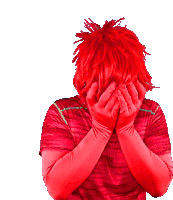 a person with red hair and red gloves covering their face with their hands