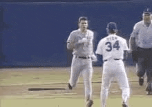 a couple of baseball players are standing on a field .