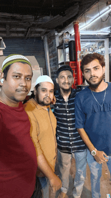 four men posing for a picture with one wearing an amir shirt