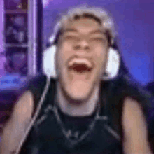 a man wearing headphones is making a funny face while laughing .