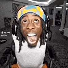 a man wearing headphones and a headband is making a funny face while sitting in a wheelchair .
