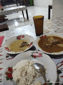 a plate of rice sits on a table next to a bowl of soup and a glass