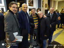 a group of men are posing for a photo with a redmi note 7 in the foreground