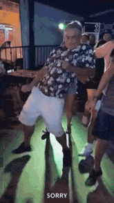 a man in a floral shirt and white shorts is dancing in a club .