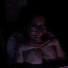 a blurry picture of a person wearing glasses in a dark room