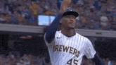 a baseball player wearing a brewers jersey is throwing a ball .
