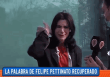 a woman in a red shirt is being interviewed by a man with a microphone and a sign that says la palabra de