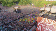 an aerial view of a crowd at a music festival with a red and white sign that says ' swirl '