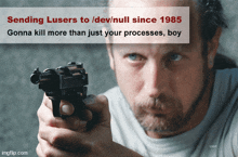 a man is pointing a gun at the camera with the caption sending lusers to dev/null since 1985