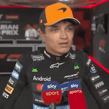 a man wearing a hat that says ' mclaren ' on it is smiling