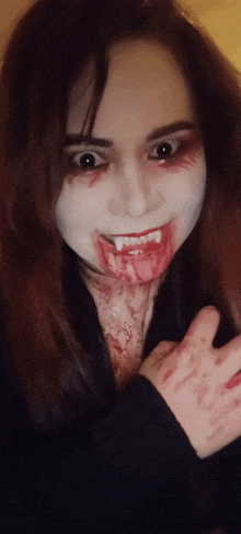 a woman dressed as a vampire with blood on her face and hands