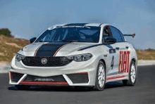 a white and red race car with the number 4 on the side is driving down a road .