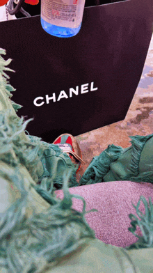 a black chanel bag is sitting on the floor