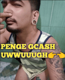 a man with a tattoo on his arm is holding his nose in front of a sign that says penge gcash uwwuuuugh