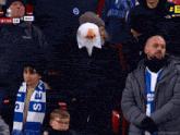 a man wearing an eagle mask sits in a crowd of people