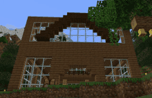 a minecraft house with a lot of windows and a tree in front of it