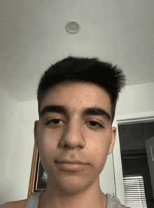 a young man is looking at the camera with a ceiling light in the background