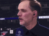 a man in a black shirt is looking up at a scoreboard that says 21:30 h